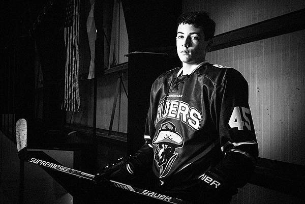 A black and white hockey portrait with American Flag in the background