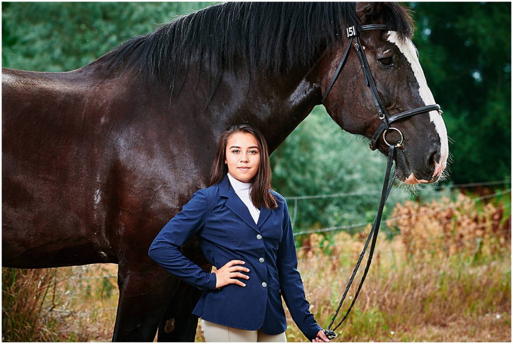 Senior girl posing next to giant percheron draft horse